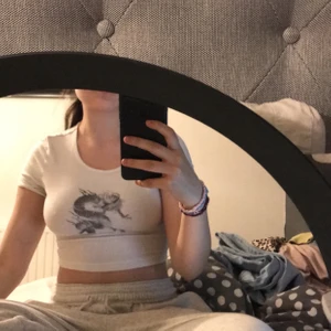 vit croppad t-shirt med orm märke - vit croppad t-shirt med orm märke, väldigt skön! Storlek: S