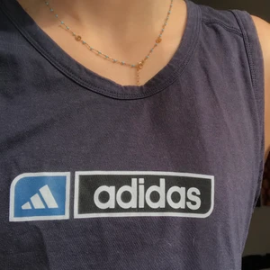 Adidas T-shirt  - Retro T-shirt som är köpt i en second hand butik! Tröjan är i super skick då den aldrig är använd, dock har jag klippt det då den var väldigt lång innan