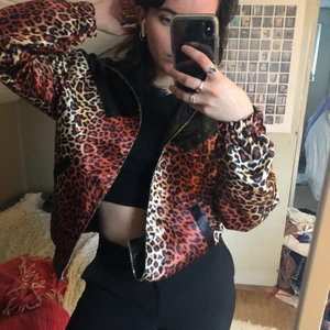 Reversible leopardjacka - En bomberjacka med krage! Leopardmönster med svarta detaljer åt ena hållet, vänd ut och in och få en svart jacka med leodetaljer!