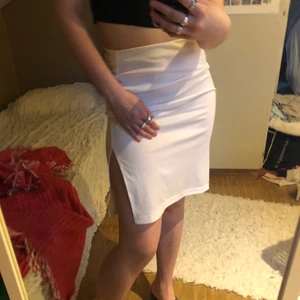 Vit kjol med slits - En vit tunn kjol i stretchigt material. Två slitsar på sidorna:) är storlek M/L men passar en S