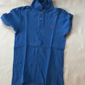 Ralph Lauren Piké Strl L/14-16 Blå - En fin Ralph Lauren Piké i strl L/14-16 Blå. Använd ett antal gånger vid särskilda tillfällen, gott skick och så gott som ny & felfri. Nypris: 1000kr