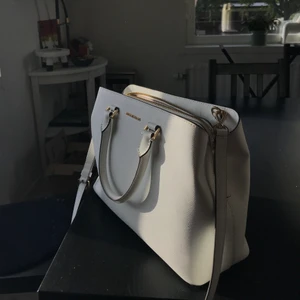 Vit MICHAEL KORS väska - Äkta Michael kors väska.  Oanvänd  Kommer med axelband och har tre fack. Nypris: 3400 