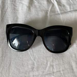 Heltvanliga svarta stora solglasögon.