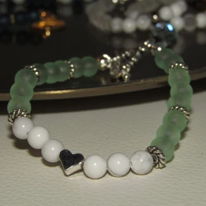 Armband - Handgjort armband av högkvalitét material. Silverfärgade detaljer och lås. Hjärtat i mitten omfångas av 6 stycken howlitstenar. Howlit sägs ge energi och minska stress för den som bär den. Frakt ingår. 