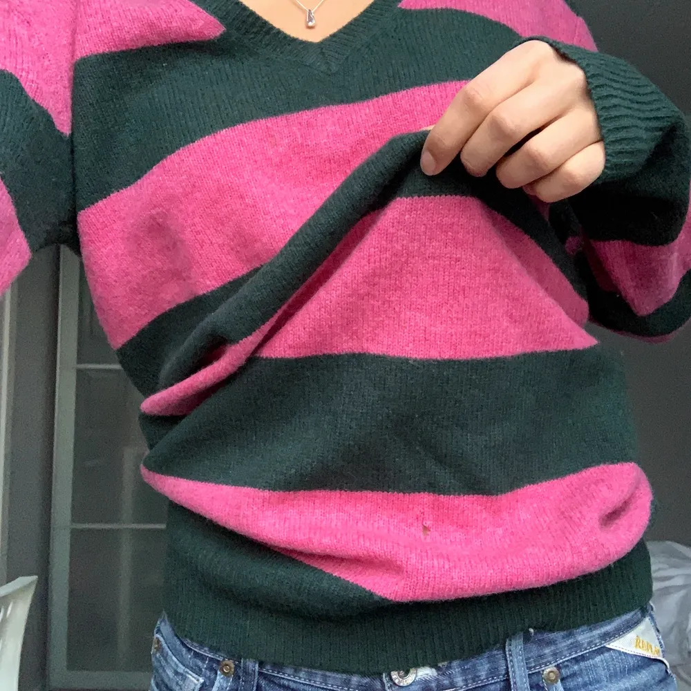 En söt randig tröja från Gant i rosa och grönt. Den håller en varm och är mysig. Den har tyvärr ett litet hål på magen (se bild) därav priset. Annars i bra skick och i storlek M.. Stickat.