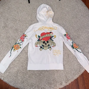 Ed Hardy hoodie - Så cool vit Ed Hardy hoodie❤️ Köpt på plick men endast använd ett fåtal gånger! Det finns dock en pytteliten fläck på mudden längst ner på ärmen så ni får skriva privat om ni vill ha bild på den! Annars superbra skick! Står storlek M men sitter tajt
