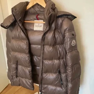 Moncler jacka - Säljer denna moncler jacka i modellen ”bady down puffer jacket”. Jackan är köpt här på plick men är tyvärr lite liten för mig så därför säljer jag den. Jackan är självklart äkta, har inget kvitto tyvärr men QR kod kopplad till monclers hemsida finns i jackan som äkthetsbevis! Inga större defekter mer än det lilla igensydda hålet på sista bilden. Jackan är köpt på NK för några år sedan, nypris 9200kr💕 (lånade bilder) BUDA MED MINST 50kr MELLAN VARJE BUD‼️