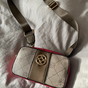 Jättesnygg handväska från Ulrika❤️ - Liten väska att ha över axeln med ljusterbar rem, men går att ta av för en clutch-look.  Mått:5x14cm