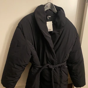 Vinterjacka dam  - Vinterjacka från HM. Den är aldrig använd och har därför prislappen kvar.   Sjukt snygg modell, den har ett band i midjan som går att ta bort. Storlek L men modellen är liten i storleken skulle jag säga, sitter nog skitsnyggt på både S/M precis som på en L!  
