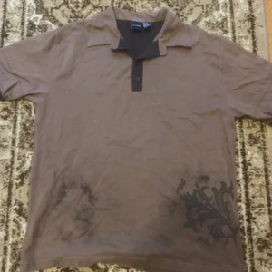 Brun t-shirt - Väldigt snygg brun t-shirt med nått mönster, den har några färg fläckar annars bra skick:) 