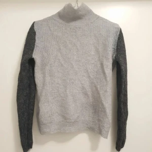 Stickad tröja från J.Lindeberg  - Tunn stickad tröja från J.Lindeberg för dam i storlek S. Tröjan är ljusgrå på bröstet och mörkgrå på armarna. I fint skick. 