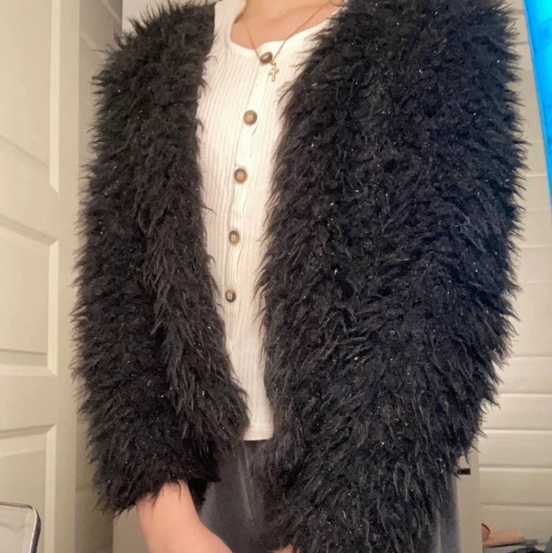 En fluffig svart kofta. - 90