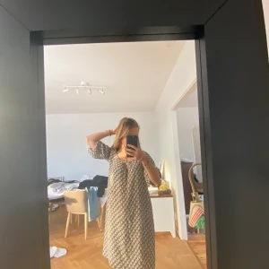 Brun och beigemönstrad siden klänning - Den här vackra klänningen i siden, är från maje och är brun men har ett ljust beige mönster, den går ner till knäna på mig och jag är 163 cm lång, sen är den även u-ringad, det går bra med leverans men då står köparen för frakten❤️🤗