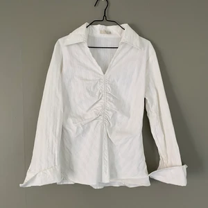 Vit y2k skjorta - En fin dam skjorta som ska sitta åt tight. Skit snyggt att ha oversized om man har storlek S-M i vanliga fall, väldigt trendigt. Inga fel! ⚠️Var god följ budgivningens regler ⚠️