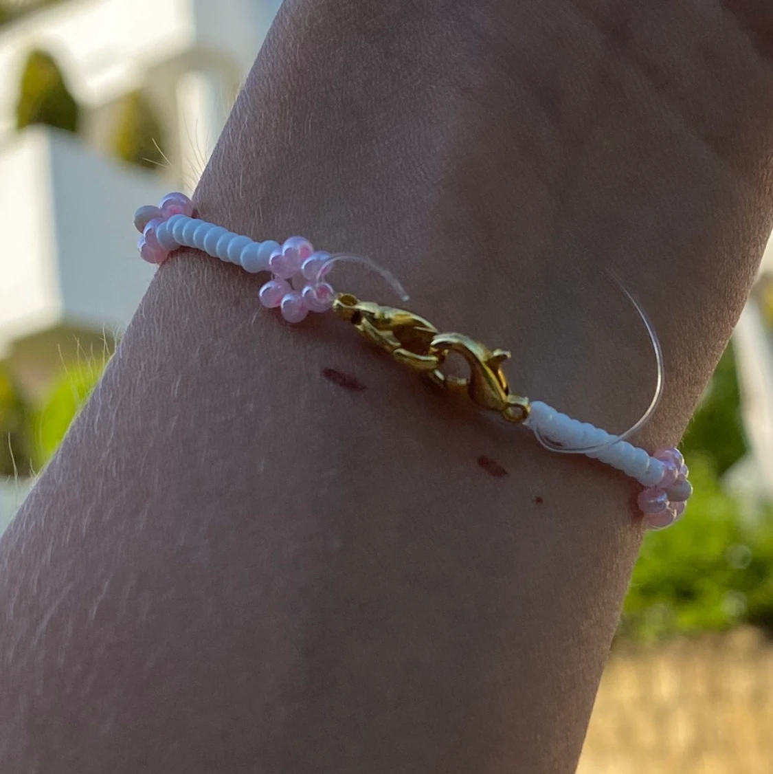 Ett vitt och rosa pärlamrband - 91