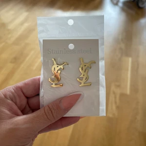 YSL Öronhängen  - Säljer ett par guldfärgade YSL Öronhängen! Hämtas i Lessebo eller fraktas mot fraktkostnad spårbar 14kr extra. Filmar alltid när jag postar, eller skickar med spårbar frakt. Skriver alltid avs! Jag garanterar en snabb och pålitlig affär! 🎀