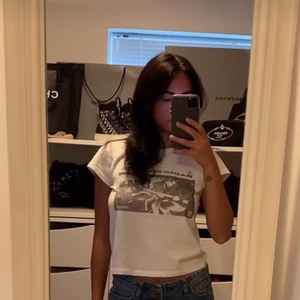 Brandy Melville t-shirt - Första bilden är lånad. Säljer tröjan på andra bilden, har lite anorlunda tryck jämfört med första men är exakt samma modell. Helt nyinköpt (prislappen kvar) men var för liten. Ny pris 220kr. 