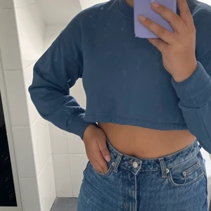 Croppad sweatshirt  - Croppad blå/grön tröja ifrån Zara! Det finns en dragsko i midjan så går att styla tröjan på massa olika sätt! Frakt tillkommer