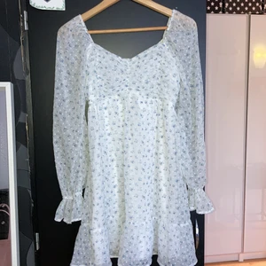 Vit/ blå blommig klänning - Säljer denna klänning från Hollister som är köpt på Zalando då den ej kommer till användning. Klänningen går ner ungefär till knäna på mig som är 170 cm. Den är endast provad och är som i nytt skick. Nypris är 629 kr, säljer för 450 + frakt. 
