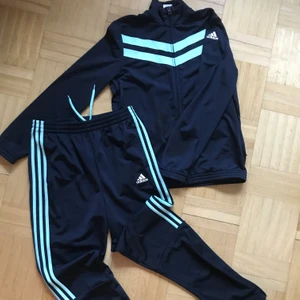 Adidas dress - Knappt använd adidas dress med lite retro känsla! Inga fläckar eller fel osv. Byxorna smalnar lite & har dragkedja nertill. Tröjan har fickor med dragkedjor framtill.. Super skön & snygg, men säljes då byxorna är för långa åt mig. Den är storlek 164, så passar xs-s (absolut en mindre M, t.o.m) 🥤🛼