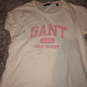 Gant tshirt  - Vit tshirt med rosa gant tryck. Ser helt ny ut förutom en liten fläck vid halsen men som säkert går bort vid strakare rengöring 