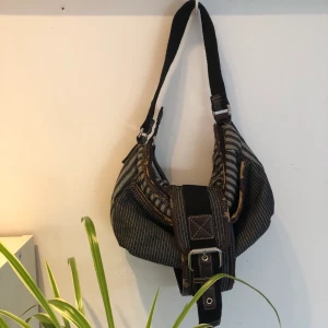 Väska - Säljer denna väska, den är rätt så sliten, vilket syns på bilden. Dem väldigt cool annars. Skriv vid frågor eller fler bilder. ☀️