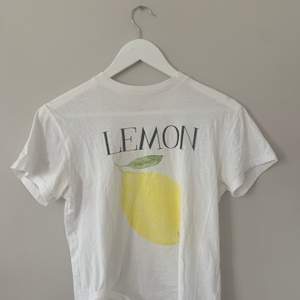 Säljer min T-shirt från Ganni i strl XS. Det är deras tryck  ”lemon”. 