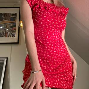 Röd klänning med volanger och körsbärsmönster, tight modell som är supersöt<3 från märket tyska märket  blutsgeschwister. Storlek XS men stretchtyg!! Köparen står för frakt 