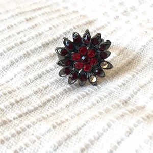 Röd blom-ring - As cool svart ring med röd blomma! 2 stenar har tyvärr lossnat :( nickelfri och reglerbar! 10kr || Du dom köpare står för frakten på 12 kr