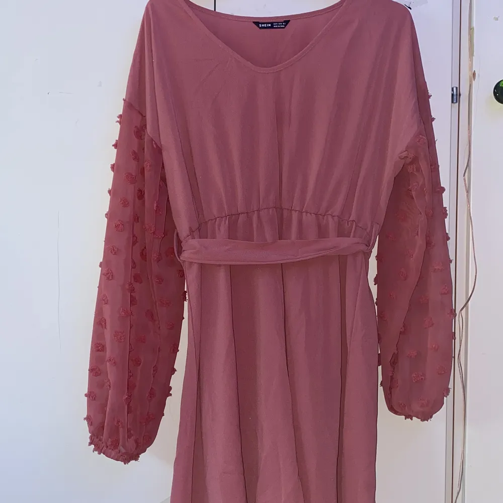 A pink short dress, with a self tie band around the waist and mostly see through arms. barely used . Klänningar.
