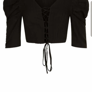 Croptop snörning S - En svart croptop endast provad från Boohoo. Säljes för att jag inte trivs med att visa min mage. Superfin annars och prislapp sitter kvar.