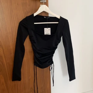 Zara tröja  - Aldrig använd tröja från zara med knytningar i sidan, sitter som en smäck! Säljer pga rensar garderob och hade två :) den har en fyrkantig urringning, super snyggt!