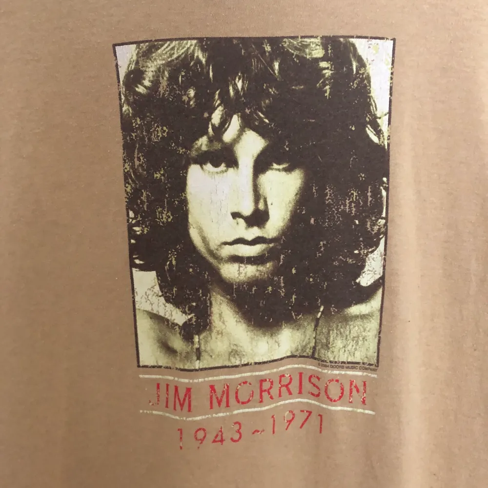 Tröja med Jim Morrison på. Köpt i Berlin och är använd. Det är ett hål under kragen men det syns ej och man kan alltid sy igen 🙂. T-shirts.
