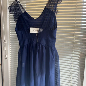Marinblå klänning - Marinblå klänning med spetsärmar, aldrig använd. Står m men mer som en s 