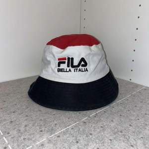 fila bucket hat i färgerna röd, vit och marinblå. fila logga fram samt ”BIELLA ITALIA”. aldrig använd, säljs då den sitter lite tajt på mitt huvud. 