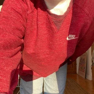 Nike röd sweatshirt - As fin tröja från nike, har en dragkedja-detalj på höger "höft" men den syns knappt alls. Kvaliten är toppen, dock har den en liten vit färgfläck högerarms-mudden som kom till när vi målade om 💕