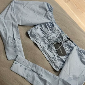 Ljusblå topp - En korsett liknande topp som är sjukt fin. Den är lite mer ljusblå än på bilderna. Toppen är helt ny och har även lapparna kvar. 