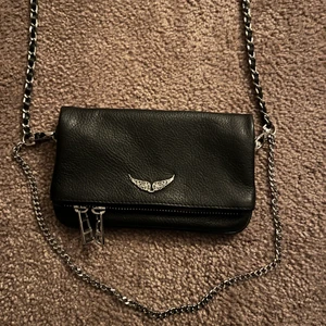Zadig & Voltaire ROCK NANO - Nu säljer jag min jättefina svarta Zadig väska. Säljer pågrund av att den tyvärr inte har kommit till användning. Ingen skada på väskan. Köparen får även med äktighetsbevis  och tygpåse som tillkommer. ❤️ PRIS KAN DISKUTERAS!! MAN BEHÖVDE EJ BUDA I BUDGIVNINGEN MAN KAN BUDA PRIVAT OCKSÅ!!!  BUD: 1300