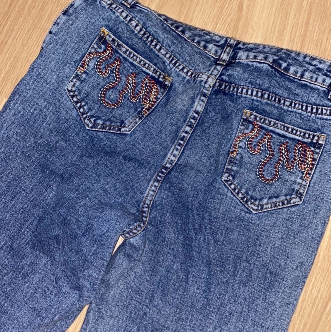 Ett par jeans med broderier på fickorna 
