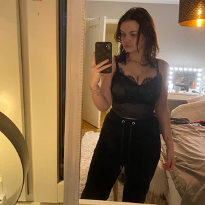 Glansig topp med spetsdetaljer - Säljer en jättefin svart glansig topp med spetsdetaljer. Dragkedja på sidan gör att den sitter perfekt och ger en kurvor, tyvärr har den blivit för tajt för mig :(( stl xs från prettylittlething