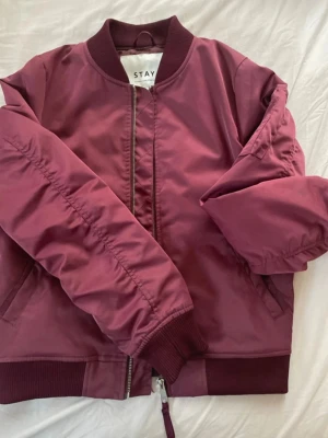 Vinröd bomberjacka från STAY - Snygg vinröd bomberjacka från STAY! Snygg och i mycket bra skick, stl S