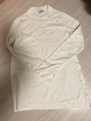 Vit ribbad tröja med knappar - Så fin och unik tröja med knappar på sidan av tröjan i storlek s.
