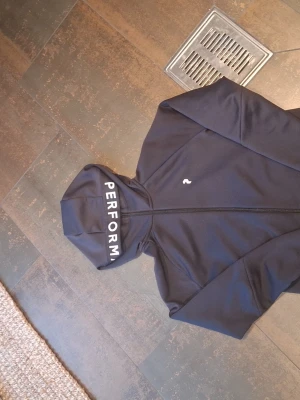 Peak Performance tröja svart  - Peak Performance hoodie i svart. I nyskick, sparsamt använd och utan slitage. Mjuk, bekväm och stilren – passar till allt. Nypris 1600 kr.