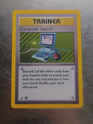 Computer search 1st Edition  - Säljer ett original Pokémonkort Trainer Computer Search från Base Set. Kortet har gul ram, motiv av en gammal dator och text på engelska. Perfekt för samlare eller dig som vill komplettera din kortlek.