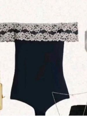 Svart off shoulder body med spets - Trendig svart body med off shoulder-design och bred vit spetskant upptill. Kroppsnära passform och elegant look, perfekt för att skapa en snygg outfit.kontakta gärna innan köp🩷.