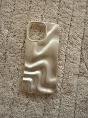 Pearl silver skimrande mobilskal (Iphone 16 pro max) - Snyggt mobilskal med pärlemorskimrande yta och vågig struktur. Skalets färg är silver