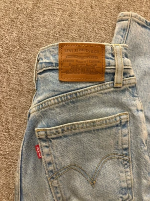 Ljusblå Levi's straight leg jeans - Ljusblå jeans från Levi's med klassisk femficksmodell och rak passform. Jeansen har den ikoniska läderpatchen bak i midjan och röd Levi's-tag på bakfickan. Tillverkade i slitstark denim med snygg tvättad look.