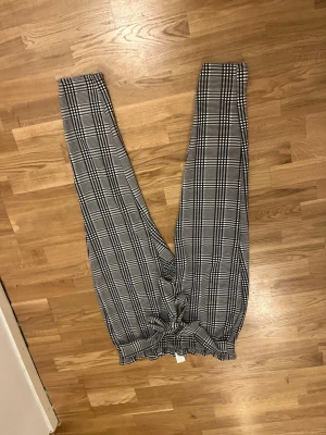 Rutiga leggings från SHEIN Curve - Säljer ett par svartvita rutiga leggings från SHEIN Curve i storlek 2XL. De har hög midja med resår och är tillverkade i mjukt stretchigt material, 97% polyester och 3% elastan. Perfekta för en trendig och bekväm look. Strechigt matrial