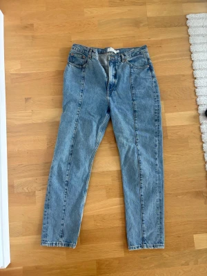 Blå jeans från & Other Stories - Säljer ett par klassiska blå  jeans från & Other Stories. Jeansen har hög midja, raka ben. Tillverkade i slitstark denim med vintagekänsla och snygga kontrastsömmar. Perfekta för en avslappnad och trendig look.
