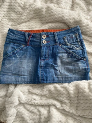 Blå jeanskjol med dubbla knappar - Snygg blå jeanskjol från Only. Midjemått ca 37cm💕pris kan diskuteras 